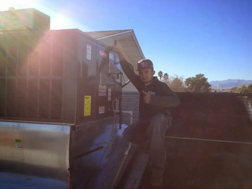 HVAC technician performing Heat Pump Repair on a rooftop unit in Greeley